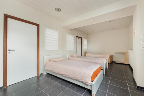 two beds in a room with two windows at jutta in Mechelen