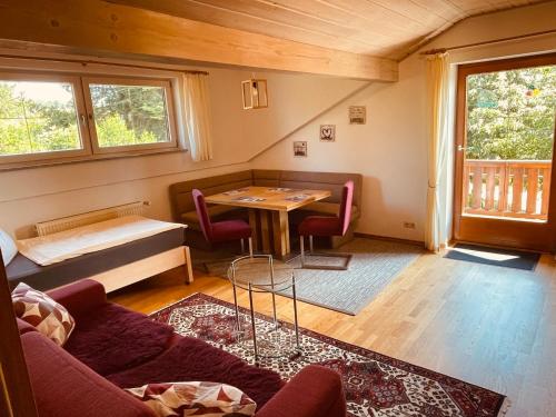 a living room with a table and a couch at Auszeit-Wohnungen in Aidenbach