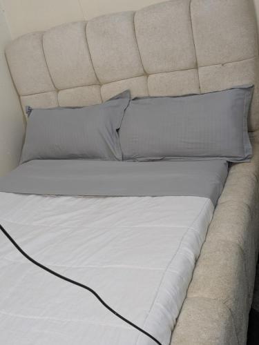 a bed with white sheets and pillows at Masaka BnB in Masaka