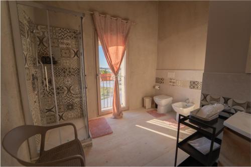 a bathroom with a shower and a toilet and a window at U Minnulitu in Caltagirone