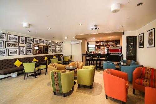 a restaurant with colorful chairs and tables and a bar at Xima Exclusive Cusco in Cusco