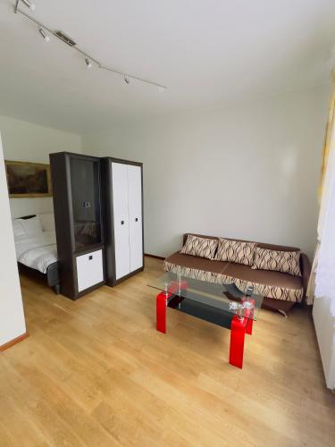 a room with two beds and a couch and a mirror at Apartament Maja 10-3 in Nowy Sącz