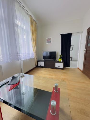 a living room with a glass table and a television at Apartament Maja 10-3 in Nowy Sącz