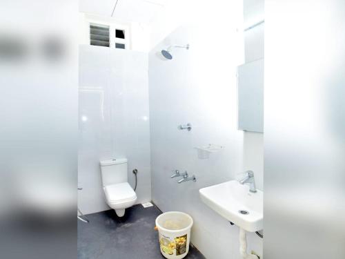 ein weißes Badezimmer mit Toilette und Waschbecken in der Unterkunft Hotel Devis Velankanni in Velankanni