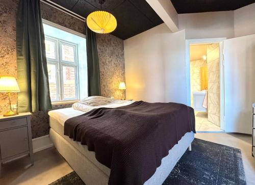a bedroom with a large bed and a window at Randalín in Åkirkeby