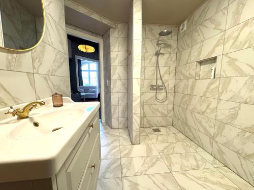 a white bathroom with a sink and a shower at Randalín in Åkirkeby