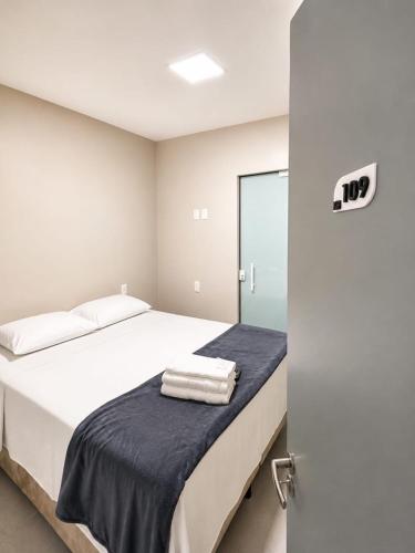 a bedroom with a bed with towels on it at Hotel Campina Center in Campina Grande