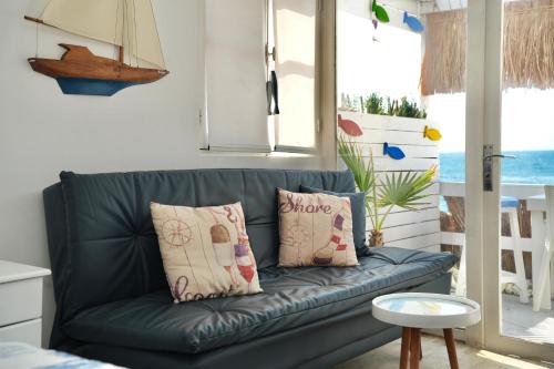 a blue couch with two pillows in a living room at Seaside Beach Chalet in Anfeh PEARL in Anfah
