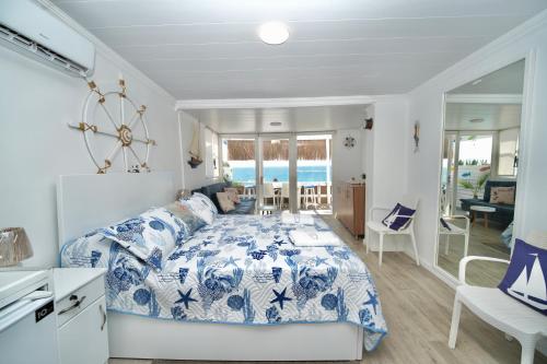 a bedroom with a bed with a blue and white comforter at Seaside Beach Chalet in Anfeh PEARL in Anfah