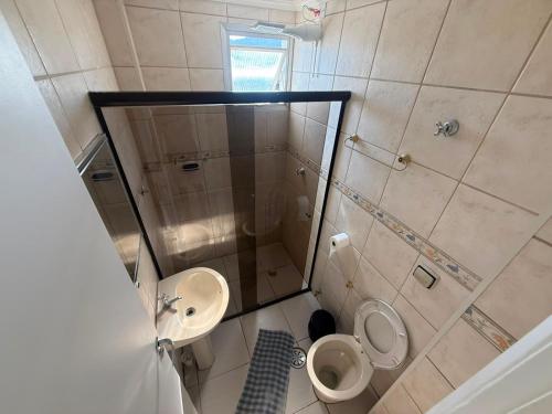 a bathroom with a shower and a toilet and a sink at Studio 1202 Confortável, Piscina e próximo a praia! in Guarujá