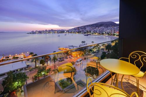 a balcony with a view of a city and the ocean at Hotel Saranda Butrinti, Affiliated by Meliá in Sarandë