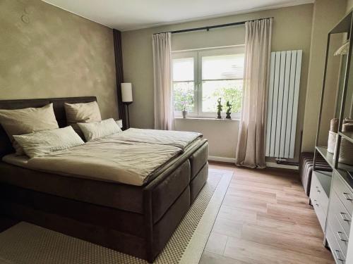 a bedroom with a large bed and a window at LIV Apartments in Stadthagen