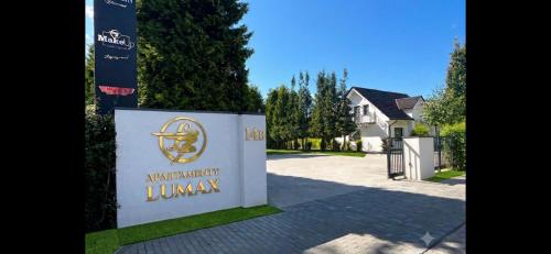 a sign in front of a house with a driveway at Apartamenty Lumax in Gryfice