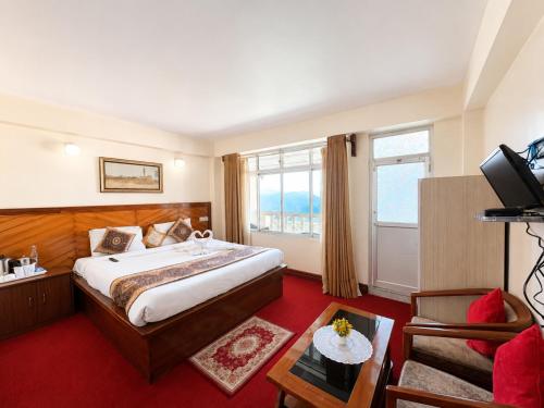 a hotel room with a bed and a television at Hotel White Yak Darjeeling in Darjeeling