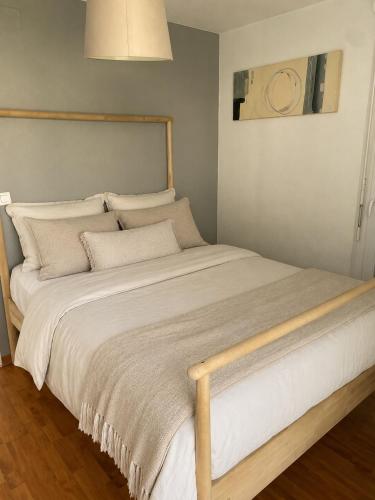 a large bed with white sheets and pillows at l'arc logement in Strasbourg