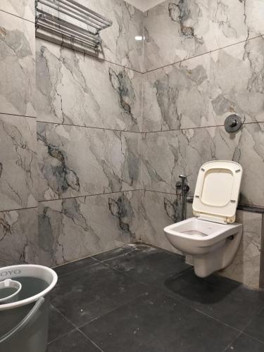 a bathroom with a toilet and a sink at Hotel Raddizone in Gandhinagar