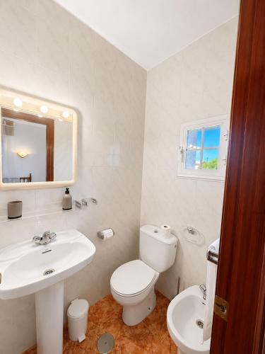 a white bathroom with a toilet and a sink at Soutullo Praia in Sanxenxo