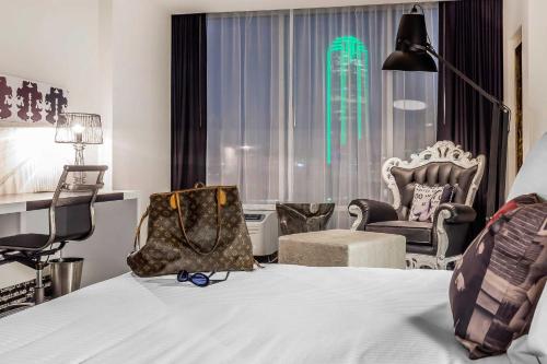a bedroom with a bed and a chair and a window at Lorenzo Hotel Dallas, Tapestry Collection by Hilton in Dallas