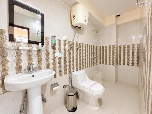 a bathroom with a sink and a toilet and a mirror at Hotel White Yak Darjeeling in Darjeeling