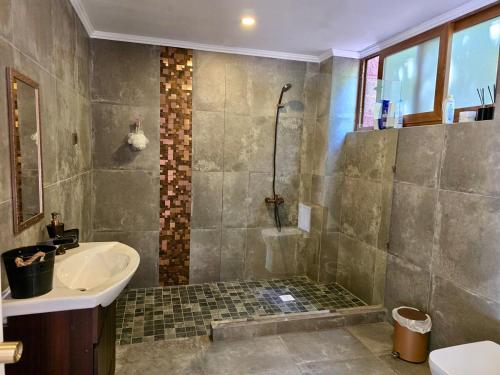 a bathroom with a shower and a sink and a sink at Casa Lago Colbun in Talca