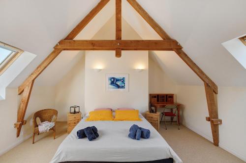 a bedroom with a bed in the attic at Longère Colpernou in Plouguernével