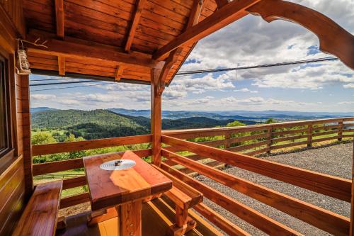 a table on the balcony of a cabin with a view at Tiny Panorama Cottages in Kamnik