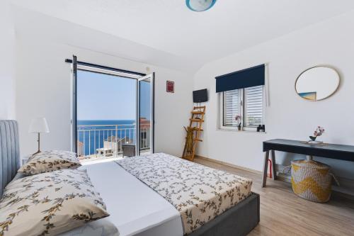 a bedroom with a bed and a large window at Apartments Joy in Cavtat
