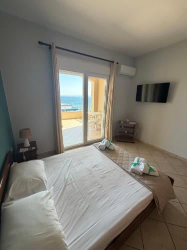 a large bed in a room with a large window at Geomelos Theodoros Apartments in Chios