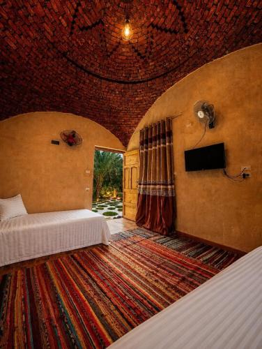 a bedroom with a bed and a large rug at Mezorin Farm & Hot Spring - Peaceful Eco-Retreat & Private Stay in Siwa