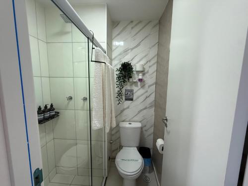 a bathroom with a toilet and a glass shower at Conforto e Localização perfeita Centro RJ 20 min Copacabana e Piscina in Rio de Janeiro