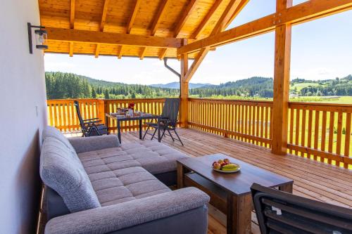 a living room with a couch and a table on a deck at Hans-Girgl-Hof in Langdorf