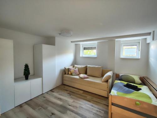 a small living room with a couch and a bed at Pfälzer Auszeit in Heuchelheim-Klingen