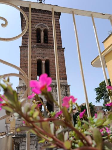 a clock tower with pink flowers in front of it at La Casa del Don in Capua