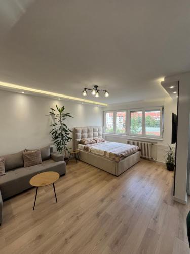 a large living room with a bed and a couch at Refresh apartman in Belgrade