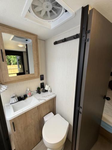 a small bathroom with a toilet and a sink at Rest Up Retreat-New Lux RV-Private-6Flags-Fire Pit-Hammock-Atlanta in Atlanta