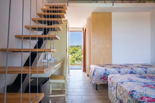 a room with two beds and a staircase in a room at Baja Azzurra in Bari Sardo