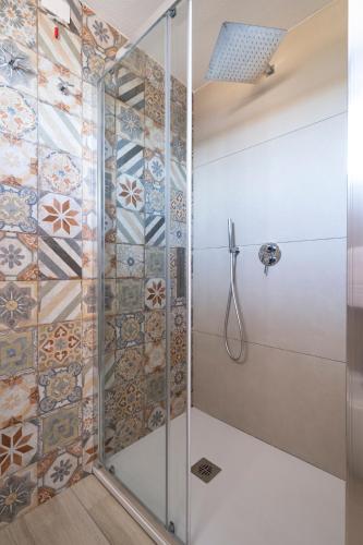 a shower in a bathroom with tiles on the wall at Baja Azzurra in Bari Sardo
