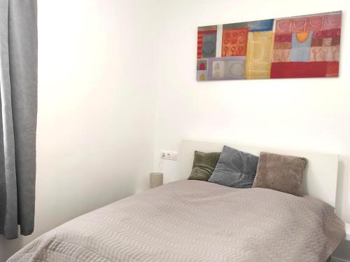 a bedroom with a bed and a painting on the wall at Parkside Home in Törökbálint