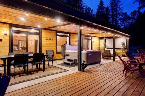 a deck with a grill and a table with chairs at Refuge Tremblant Spa Ski 11min in Lac-Superieur