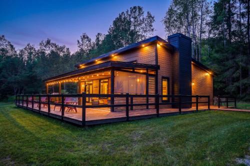 a house with a large deck in the grass at Refuge Tremblant Spa Ski 11min in Lac-Superieur