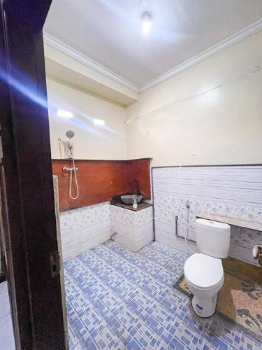 a bathroom with a toilet and a sink at Sunrise Lodge and Lounge Hotel in Panji