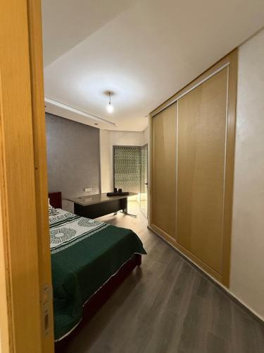 a bedroom with a bed and a large sliding door at Appartement a meknes in Meknès