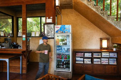 a man is standing in front of a refrigerator at Maewin Resort in Ban Huai Rin