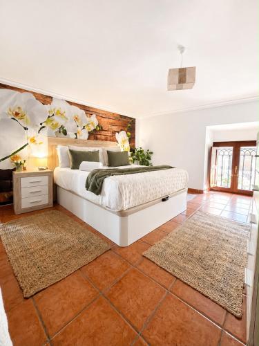 a bedroom with a bed with a wall with flowers at Casa El Rubio in San Vicente de la Sonsierra