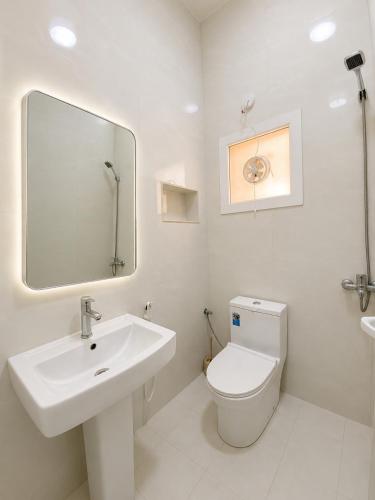 a white bathroom with a sink and a toilet at Aknan Center Market in Salalah