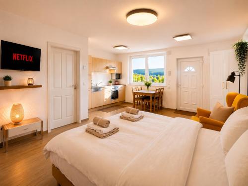 a bedroom with a white bed with two towels on it at Alb-Welle I Design-Apartment mit privater Sauna & Badkap-Nähe in Albstadt