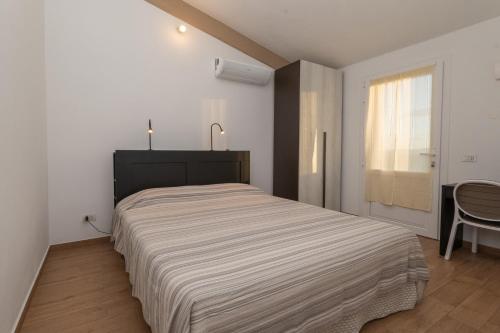 a bedroom with a bed and a table and a window at Giardino sulla Maremma in Grosseto