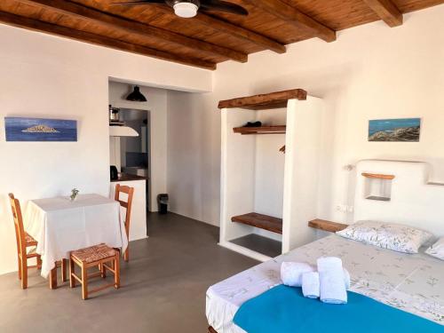 a bedroom with two beds and a table in a room at KOLOMBA GUESTS House in Vrachonisída Skylonísi