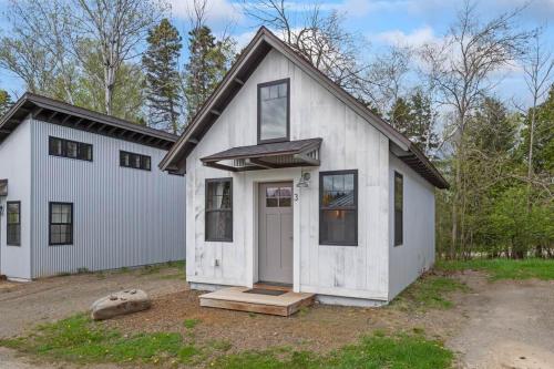 a white house with a front door and windows at The Evergreen | Walk to Rangeley Lake, Sled & ATV Access in Rangeley