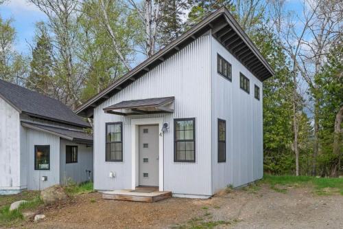 a white house with a black roof at The Ridgeline | Near Saddleback • Walk to Rangeley Lake in Rangeley